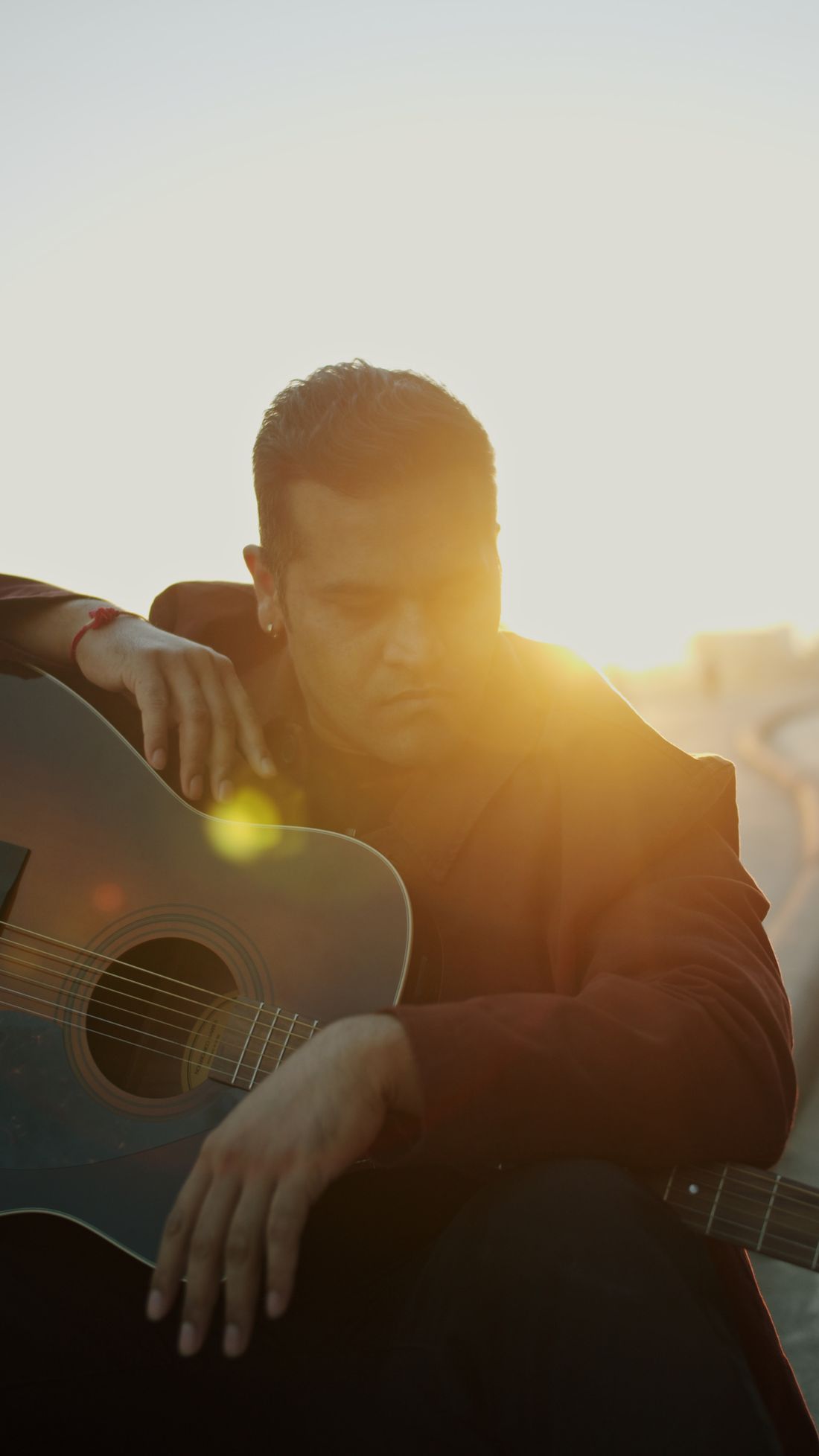 ATULIS with guitar, sun behind