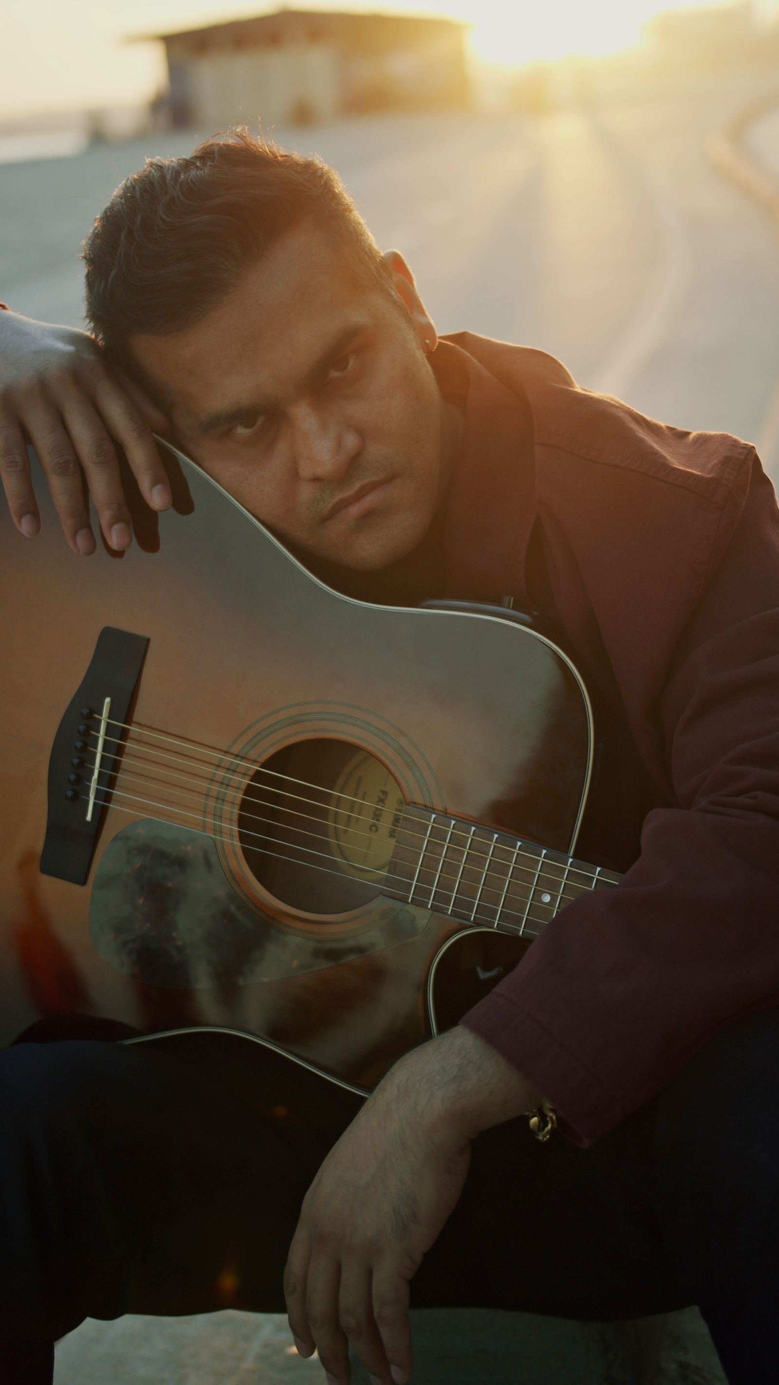 ATULIS resting against a guitar at golden hour